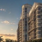 Fachada de una torre de condominios madura frente al mar con andamiaje de mantenimiento en varios pisos.