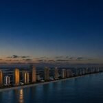Vista aerea de la costa de Sunny Isles al atardecer con reflejo dorado sobre el mar